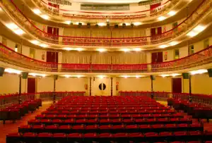 "Vista interior del Teatro Leal en La Laguna, mostrando su elegante arquitectura con detalles ornamentales, balcones decorativos y un escenario iluminado preparado para una función."