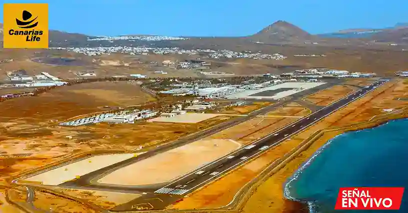 Aeropuerto de Lanzarote con pista, edificios y costa cercana, montaña en el fondo; Canarias Life y Señal En Vivo en la esquina superior izquierda.