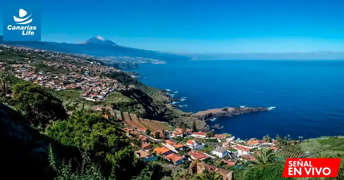 Panorámica de una costa con casas, montañas y mar, en la que se aprecian las escaleras agrícolas y el paisaje natural.