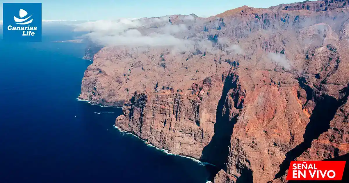 "Costas rocosas de Tenerife con mar azul, nubes bajas, y logo 'Canarias Life'".
