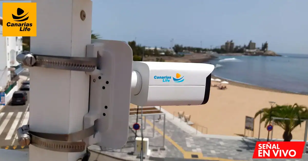 Cámara turistica con logo "Canarias Life" en una playa, señal de transmisión en vivo.