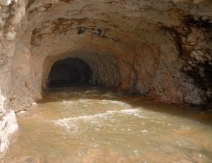 Túneles antiguos construidos con piedras, probablemente utilizados para almacenamiento o defensa, se observan desde una perspectiva lateral y frontal.