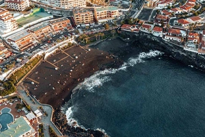 Vista aérea de la hermosa playa La Arena con sus instalaciones en Puerto Santiago en el municipio de Santiago del Teide
