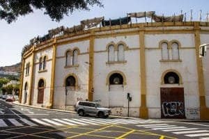 Puerta de entrada a un edificio histórico en Canarias, con arquitectura clásica y grafiti en la base.