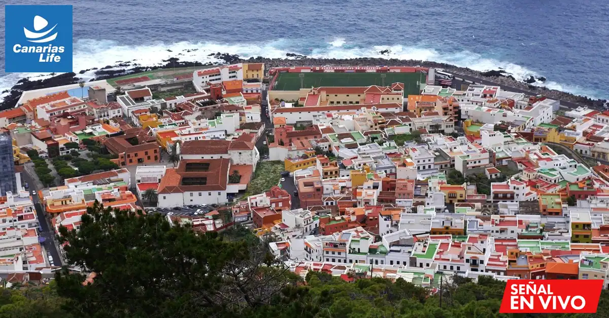 Pueblo costero de Garachico con edificios coloridos, playas y mar, con logo "Canarias Life" e indicación "SEÑAL EN VIVO".
