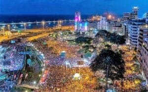 Carnevale di Tenerife, Festival notturno vibrante con grande affluenza, illuminazione colorata e paesaggio urbano costiero.