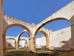 monumenti preispanici Fuerteventura, rovine medievali con archi, colonne e pareti in rovina sotto un cielo azzurro chiaro.