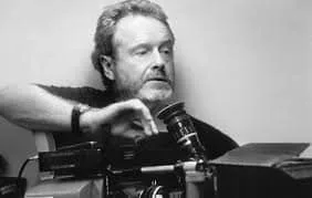 A man works with a professional camera, adjusting some element while surrounded by technical equipment.