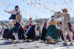 Danza tradizionale con abbigliamento regionale, musica all'aperto, celebrazione culturale.