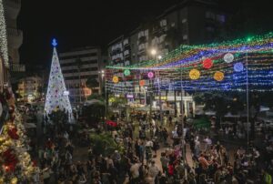 Árbol de Navidad iluminado en calle festiva canaria, celebración navideña en Canarias.