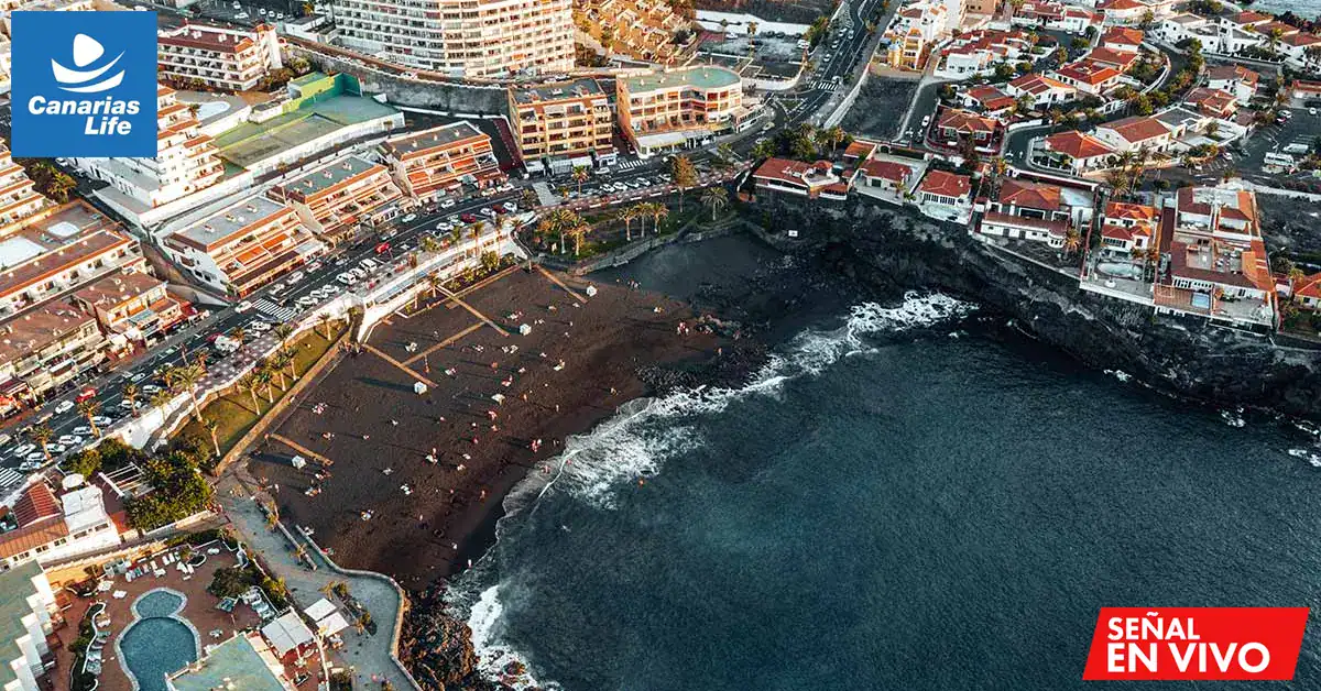 Caminata en la playa volcánica de Lanzarote, Canarias, con vistas del océano Atlántico y la costa.