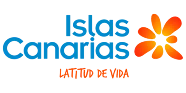 Turismo de Canarias 373x187 Logotipo de «Turismo de Canarias» con una forma estilizada de color azul que recuerda a un paisaje o a una ola, acompañada de una flor tropical de color naranja en la esquina superior derecha. En la parte inferior aparece el texto en naranja