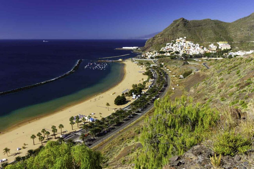 Aguas tranquilas de la Playa de Las Teresitas con el dique y el pueblo de San Andrés al fondo, Tenerife