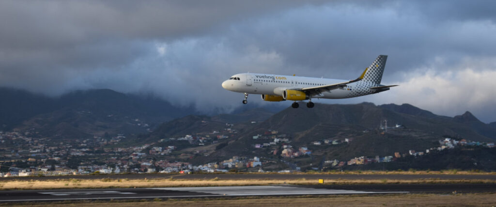 Avión aterrizando en el aeropuerto Tenerife Norte Los Rodeos entre nubes con las montañas de Anaga al fondo, Tenerife