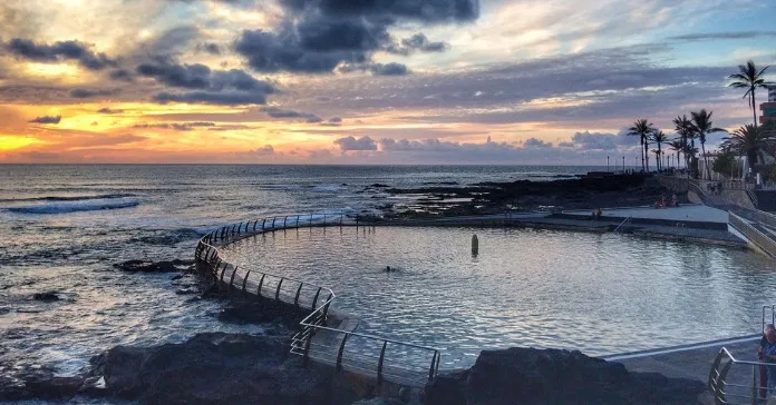 Piscina natural de Punta del Hidalgo al atardecer con olas y rocas volcánicas, La Laguna, Tenerife