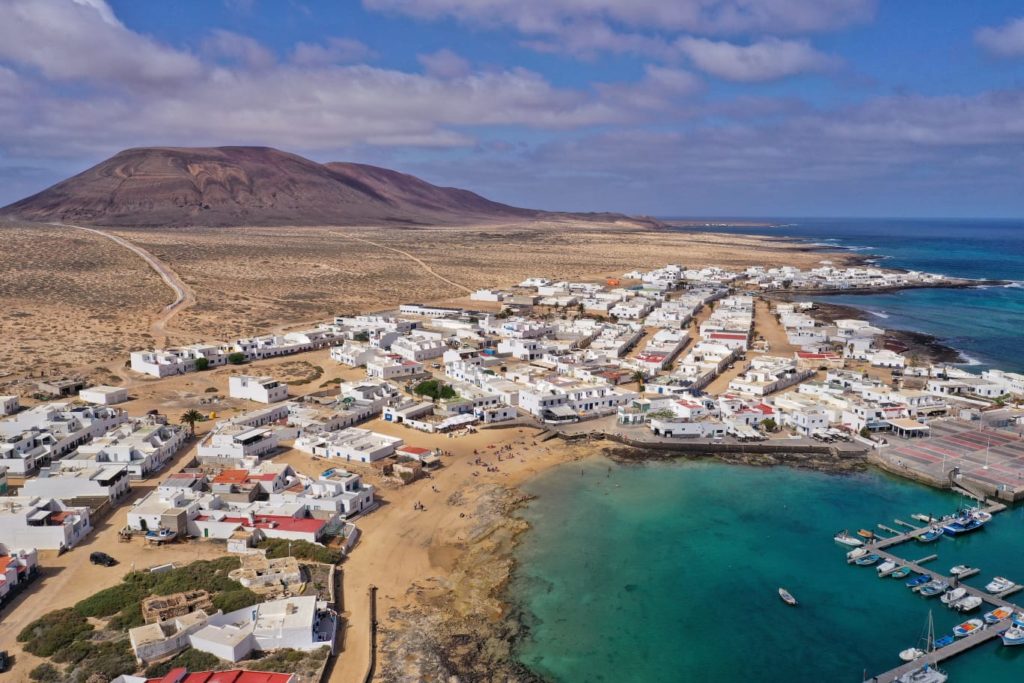 Vista aérea de Caleta del Sebo en La Graciosa con el puerto, las casas blancas y el Atlántico, Lanzarote