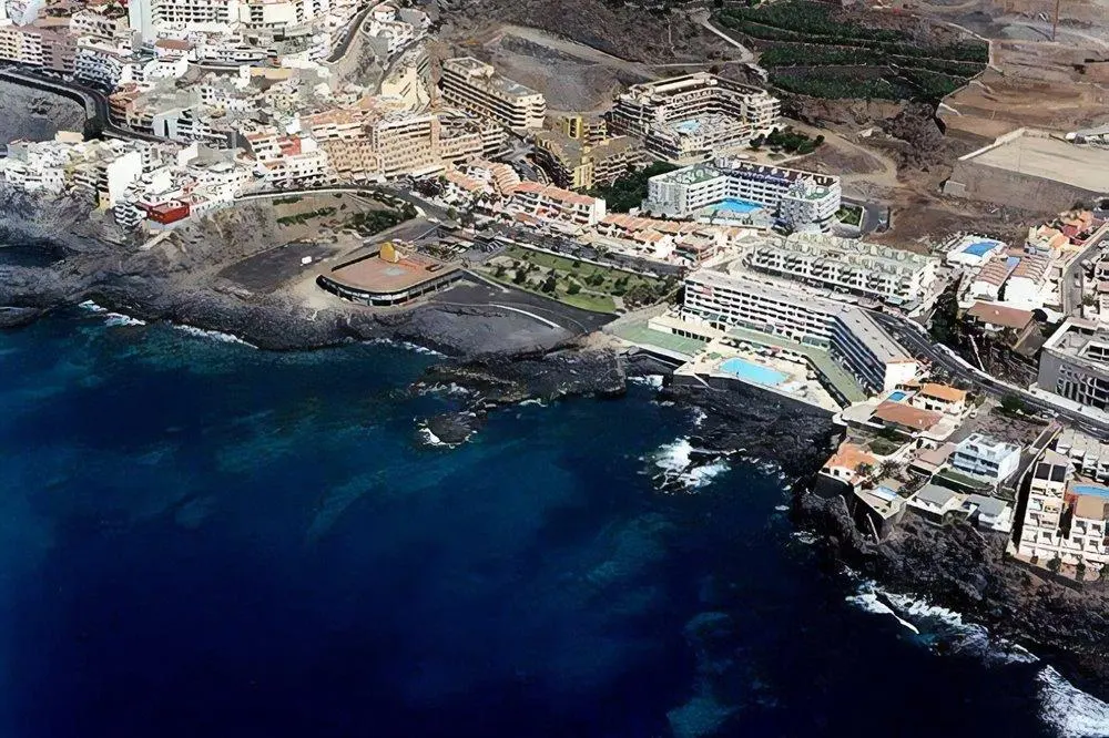 Vista aérea de Playa La Arena con arena negra volcánica y el paseo marítimo de Puerto de Santiago, Santiago del Teide, Tenerife