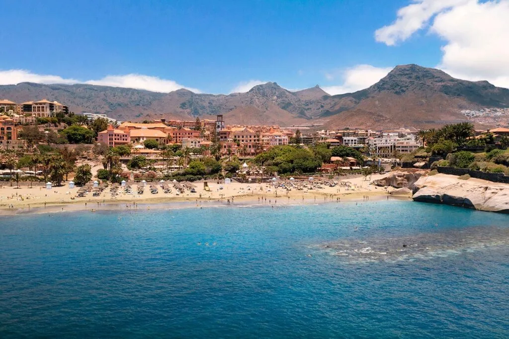 Arena dorada y aguas cristalinas de la playa del Duque Costa Adeje con Bandera Azul Tenerife