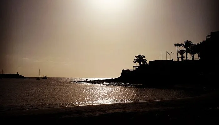 Atardecer en playa Las Marañuelas Mogán con arena oscura y mar en calma, Arguineguín, Gran Canaria