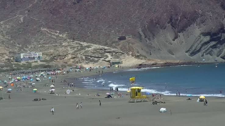 Bañistas en Playa La Tejita con el cono volcánico de Montaña Roja, Granadilla de Abona, Tenerife