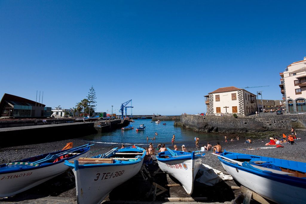 Muelle de Puerto de la Cruz con barcos de pesca y playa en Tenerife norte