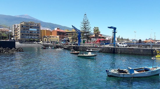 Muelle turístico de Puerto de la Cruz con pescadores y vistas al Atlántico en Tenerife