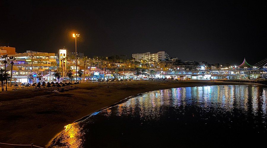 Playa La Pinta Costa Adeje imagen nocturna con arena dorada y Puerto Colón al fondo