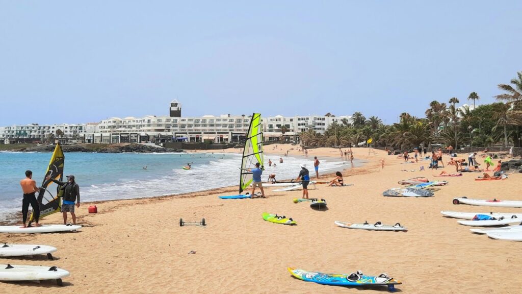 Playa Las Cucharas Costa Teguise Lanzarote con deportistas de windsurf y arena blanca