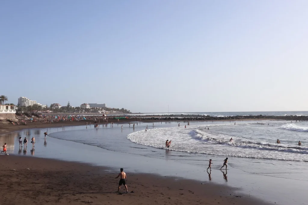 Playa de Troya en Las Américas Tenerife con arena dorada y espigones de protección, sur de Tenerife