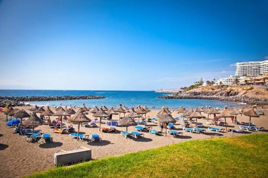 Playa del Bobo Tenerife con arena volcánica oscura y aguas tranquilas en Costa Adeje