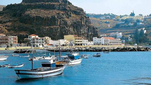 Puerto de Santiago La Gomera con embarcaciones pesqueras y acantilados volcánicos al fondo, Alajeró