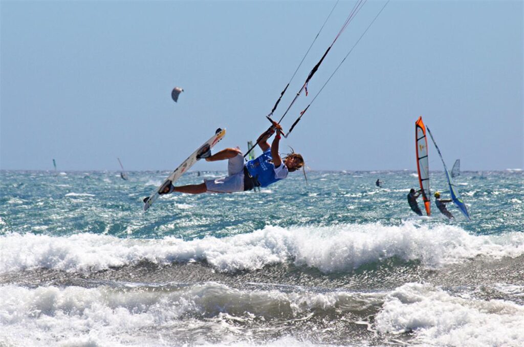 Rider de kitesurf sobrevolando las olas de El Médano con viento alisio, Granadilla de Abona, Tenerife