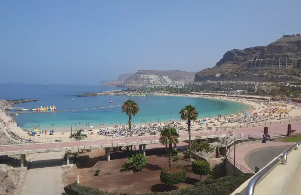 Vista de Playa Amadores desde el paseo marítimo con acantilados al fondo, Mogán, Gran Canaria