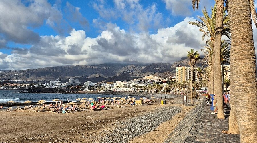 Vista de la Playa de las Américas con arena dorada, aguas tranquilas y el paseo marítimo, sur de Tenerife