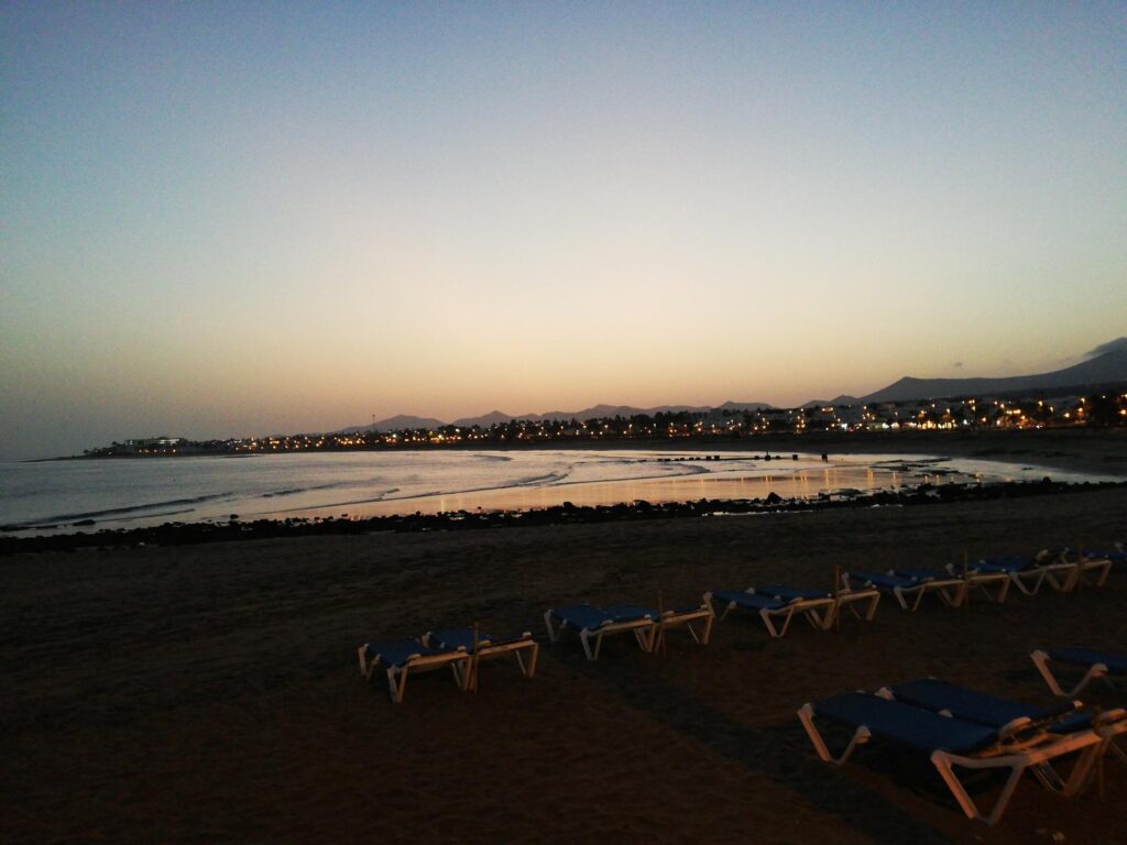 Webcam playa Los Pocillos Lanzarote con atardecer sobre el Atlántico y Puerto del Carmen al fondo
